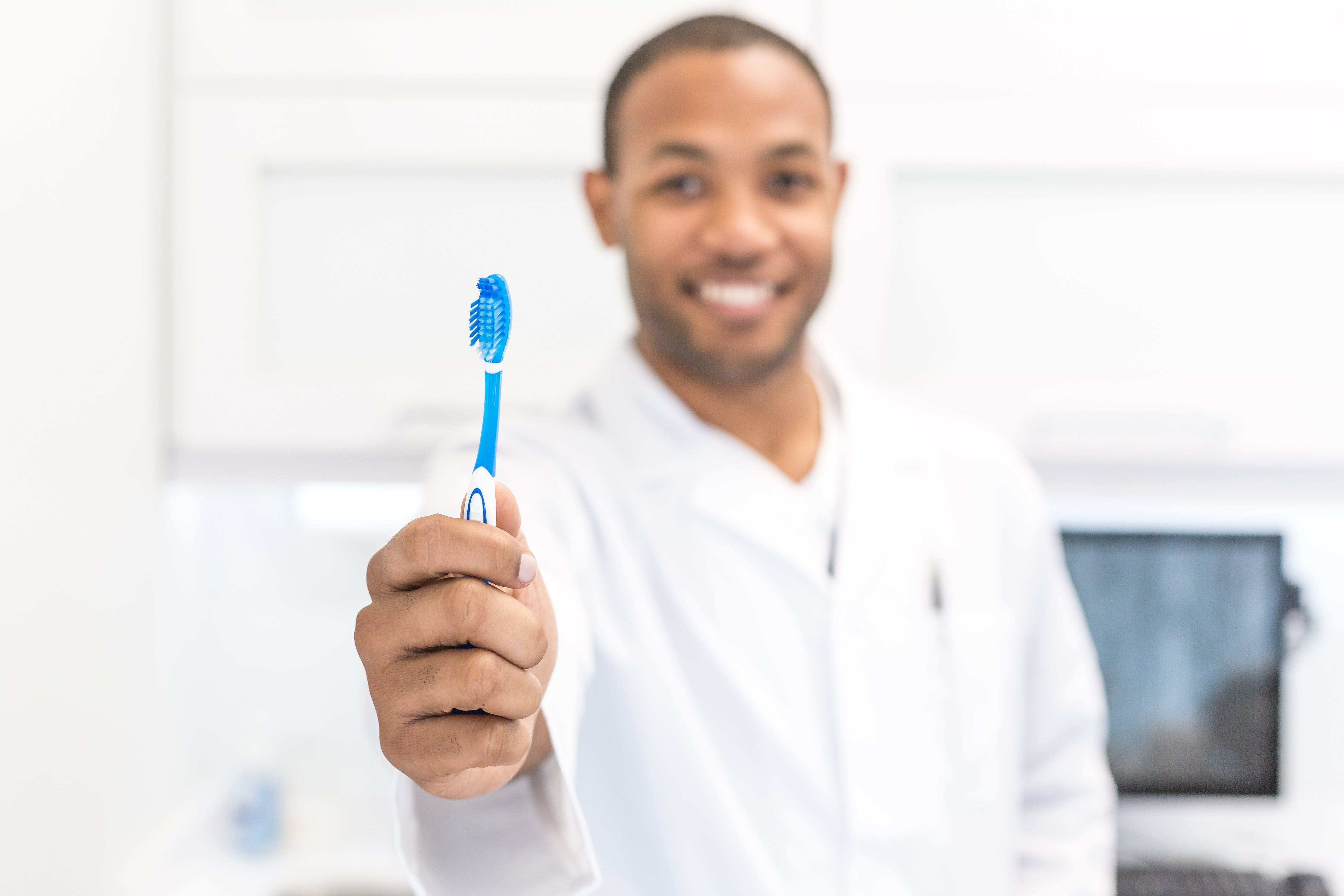 dentist holding a toothbrush in dental office